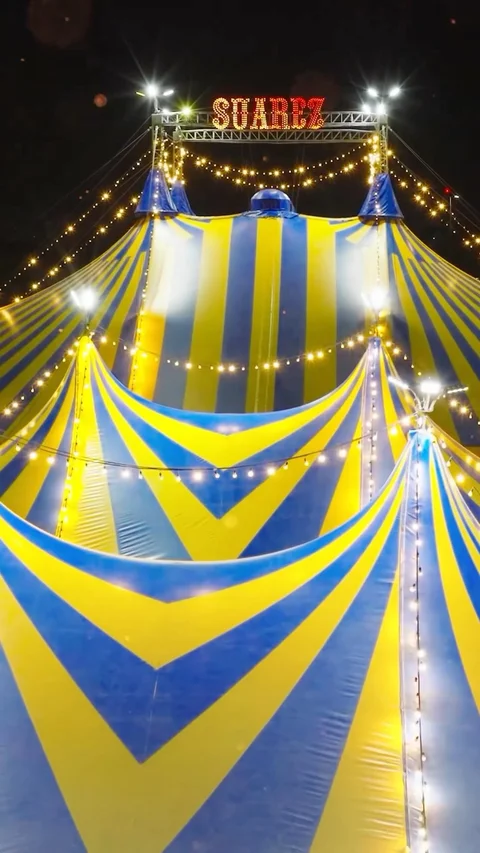 Carpa azul y amarilla iluminada de noche.