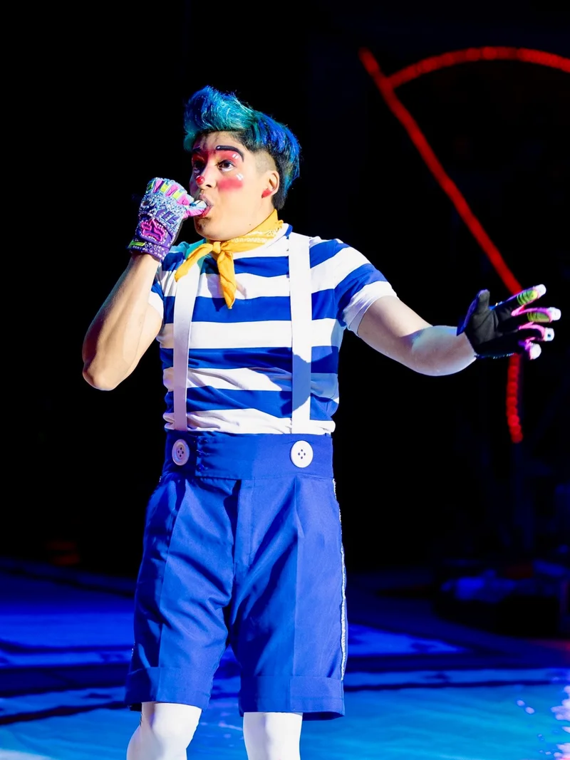 Artista del Circo Hermanos Suárez, con traje azul a rayas, en plena actuación.